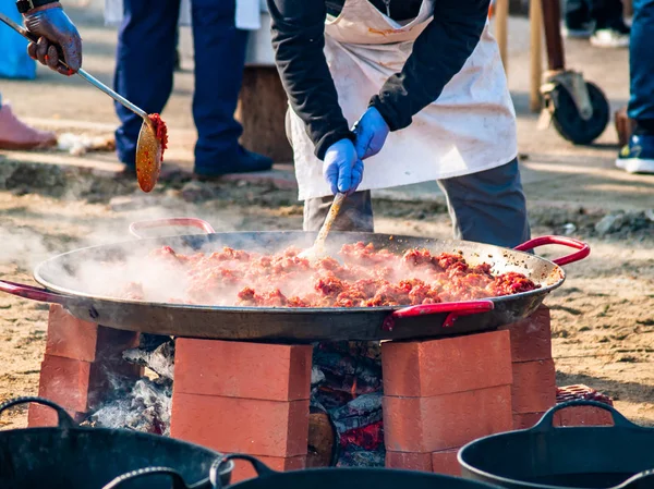 Persona irriconoscibile che cucina cibo tradizionale chiamato chichas per strada a una festa popolare in un villaggio in Spagna — Foto Stock