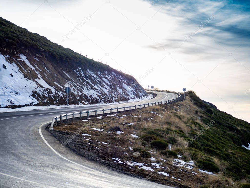 Very closed curve on a dangerous high mountain road with cloudy skies and snow on La Covatilla, Bejar (Salamanca)