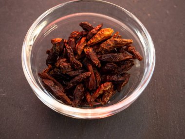 Bir kayrak plaka üzerinde baharatlı cayenne ile cam bir kase