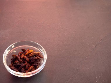 Bir kayrak plaka üzerinde baharatlı cayenne ile cam bir kase