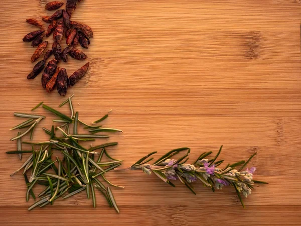 Cayena picante y hierba de romero en una mesa de madera — Foto de Stock