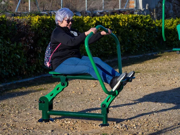 Een senior vrouw met wit haar het beoefenen van gymnastiek in een bio-gezond Park — Stockfoto