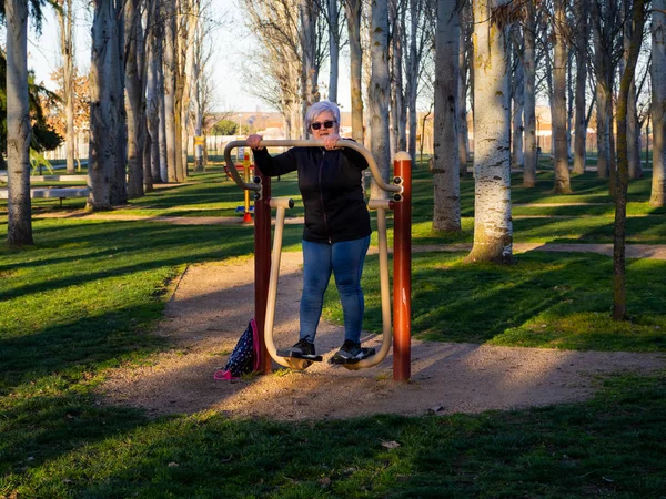 Egy magas rangú nő fehér hajú gyakorló torna egy bio-egészséges parkban — Stock Fotó