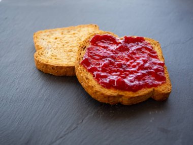 Arduvaz plakasında ahududu reçeli ile iki dilim tost