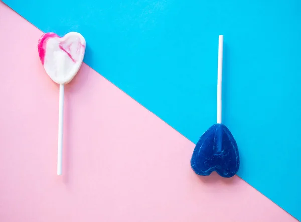 Pink and white and blue lollipops on a pink and blue background