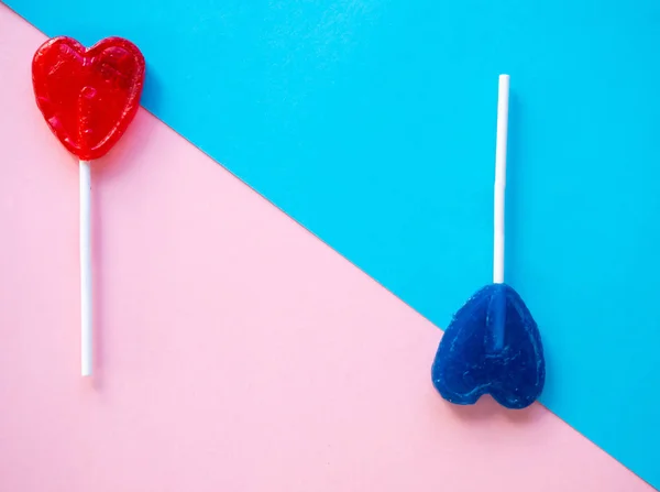 Red and blue lollipops on a pink and blue background