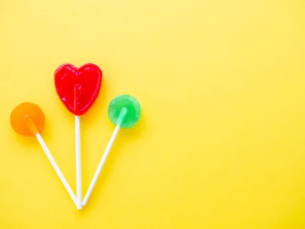 Verschillende lollies op een gele achtergrond — Stockfoto