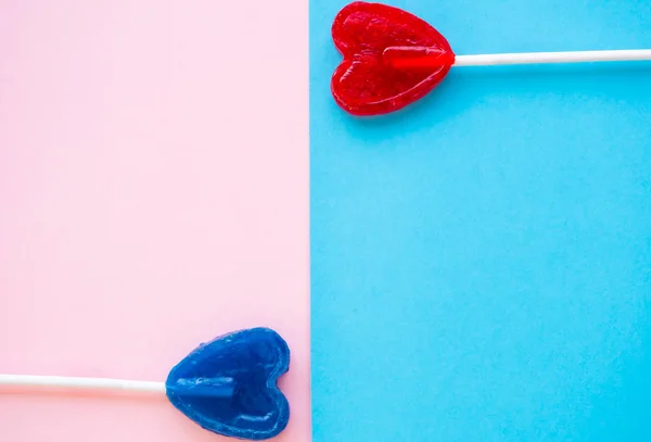 Red and blue lollipops on a pink and blue background