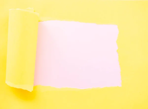 Papel amarillo desgarrado aislado en rosa pastel — Foto de Stock