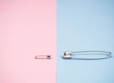 Bir erkek ve bir kadını temsil eden iki güvenlik pimi. Machismo ve feminizm kavramı