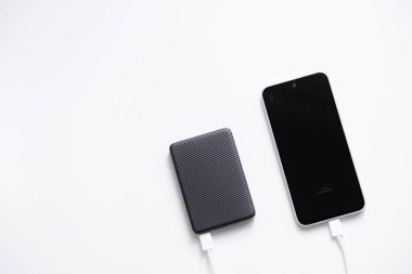 Cep telefonu bataryasını şarj etmek için taşınabilir güç bankası, beyaz arkaplanda izole.