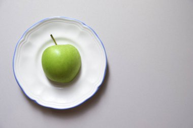 Tabakta yeşil bir elmanın yakın çekimi.