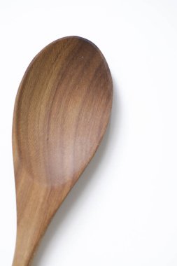 Beyaz arkaplanda izole edilmiş tahta kaşığın yakın çekimi