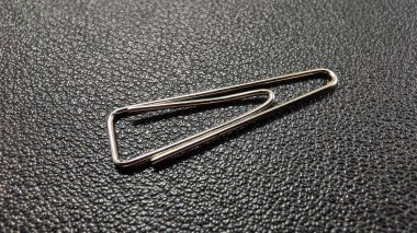 Siyah arka planda gümüş renkli ataç, ön manzara. siyah deri arkaplan