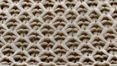Altıgen dikişin yakın çekimi, iç içe geçmiş altıgenlere benzeyen dokulu bir kumaş oluşturan bir örgü deseni.
