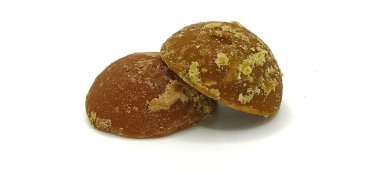 Beyaz zemin üzerinde izole edilmiş yarı dairesel şekillerde iki parça doğal kahverengi palmiye şekeri veya hindistan cevizi şekeri ön görünümü