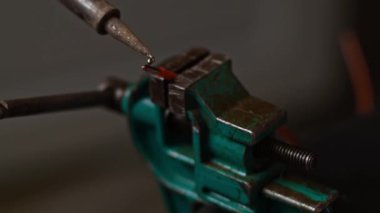 Kırmızı kabloyu akı ve dumanla kaplıyorum. Küçük bir mengenede kablo.