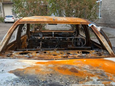 Bir yolcu vagonunun içi yangınla tamamen yok oldu. Ağır hasar gören koltuklar ve metal kalıntıları, savaş ve mülkiyet kaybının sonuçlarını gösteriyor..