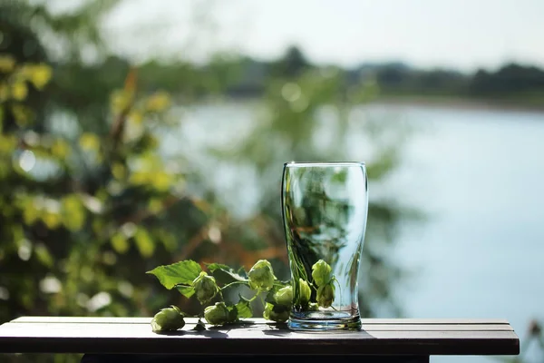 glass of beer on the table by the river