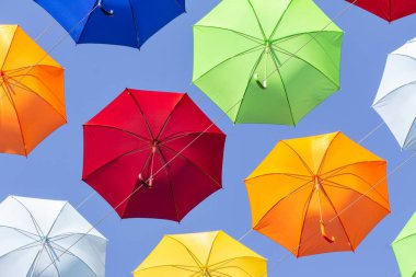 Mavi gökyüzünün zemin karşı renkli şemsiyeler