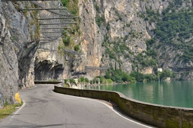 Yol bir gölde taşın altına. Doğal asfalt yol yol taşkın bir kayalığın gidiyor. Göl kıyısı öyle. Gölün adı d'Iseo ve Lombardiya, İtalya'da.