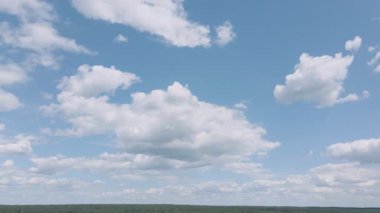 Güzel zaman dilimi mavi gökyüzünde hareket eden beyaz bulutları gösteriyor. Doğa, arkaplan ve yaratıcı projeler için atmosferik çekim.