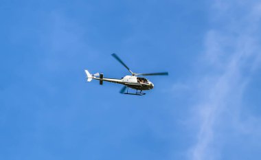 Turist helikopter üzerinde açık mavi gökyüzü uçan