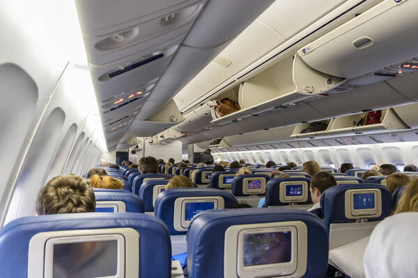  Interior of large passengers airplane with people on seats before take off