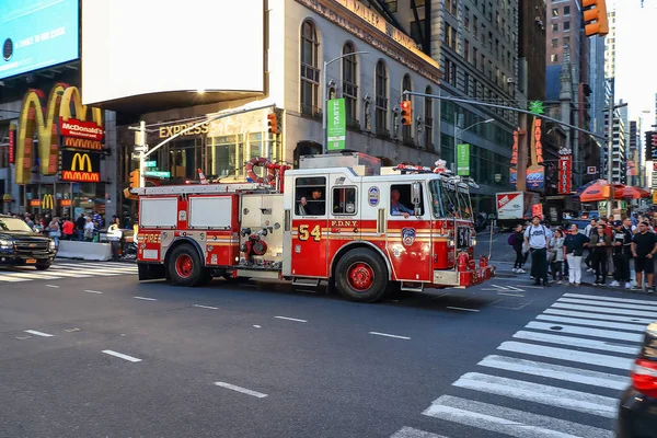 FDNY acil kamyon geçerken hızlı Times Square, New York'ta gün batımında.