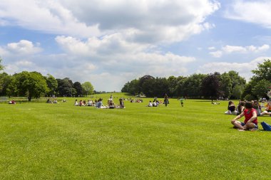 Kızlar ve erkekler için öğle vakti, bulutlu ve güneşli bir gün, Kilkenny İrlanda tarihi Kilkenny şatoda güneşlenme.