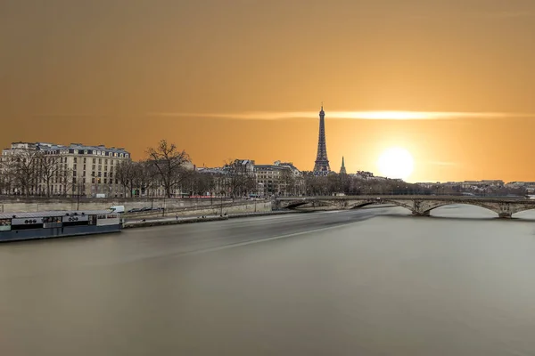 Long exposure photography of sunset in Paris in a cloudy day, with Seine river and Eiffel tower