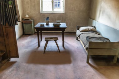 Auschwitz, Poland - June 2, 2018: Bedroom of a kapo or prisoner functionary. Was a prisoner in a Nazi concentration camp who was assigned by the SS guards to supervise forced labor or carry out administrative tasks clipart