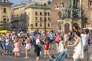Krakow, Polonya 5 Haziran 2018: Çocuklar oyun eski şehir Krakow, Polonya, ana meydanında sabun köpüğü ile şehrin merkezinde yer alan ana kentsel alandır. 13. için uzanıyor 