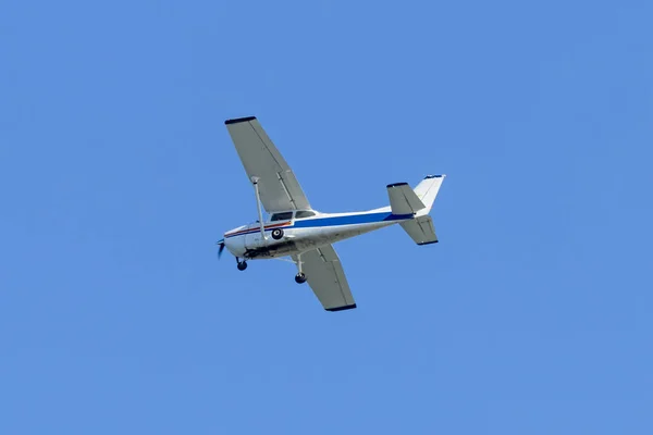 単一エンジン軽飛行機澄んだ青い空を飛んでいます — ストック写真