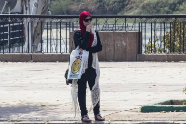 Aswan, Mısır - 11 Eylül 2018: Sokakta bir suyu içme Türban Arap kadınla