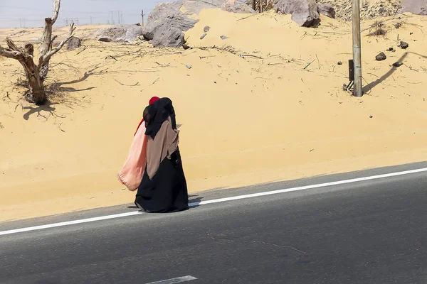 阿拉伯妇女穿着传统服装走在沙漠 — 图库照片