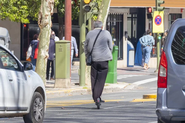 Man op een elektrische scooter over het stadsverkeer — Stockfoto