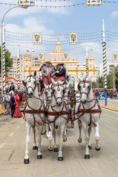 Севиль, Испания - 5 мая 2019 года: Люди, въезжающие на конной тягаче — стоковое фото