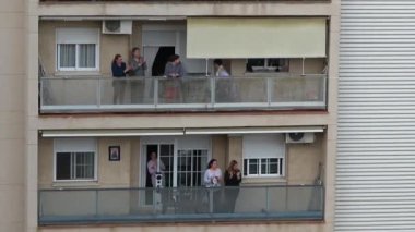 Huelva, İspanya - 20 Nisan 2020: Vatandaşlar ölümcül koronavirüs salgını sırasında her gün saat 8 'de evlerinde balkonlarda alkışlıyorlar. İspanya 'da karantinadaki insanlar