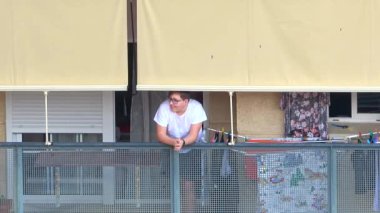 Huelva, İspanya - 8 Nisan 2020: Vatandaşlar ölümcül koronavirüs salgını sırasında her gün saat 8 'de evlerinde balkonlarda alkışlıyorlar. İspanya 'da karantinadaki insanlar