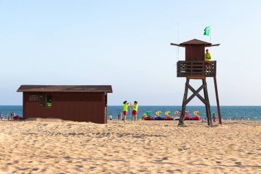 Punta Umbria, Huelva, İspanya - 9 Temmuz 2020: Cankurtaran Kulesi ve ilk yardım evi çalışanları gün sonunda temizlik ve toplama yapıyorlar