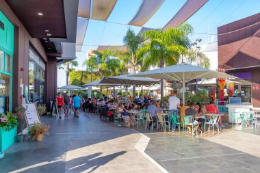 Punta Umbria, Huelva, İspanya - 3 Haziran 2020: Huelva, İspanya - 27 Temmuz 2020: Holea Alışveriş Merkezi 'nde bir kafe ve barın terasında oturan insanlar. Bazıları covid-19 nedeniyle koruyucu maske takıyor. Huelva, İspanya