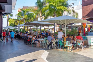 Huelva, İspanya - 27 Temmuz 2020: Holea Alışveriş Merkezi 'nde bir kafe ve barın terasında oturan insanlar. Bazıları covid-19 nedeniyle koruyucu maske takıyor. Huelva, İspanya