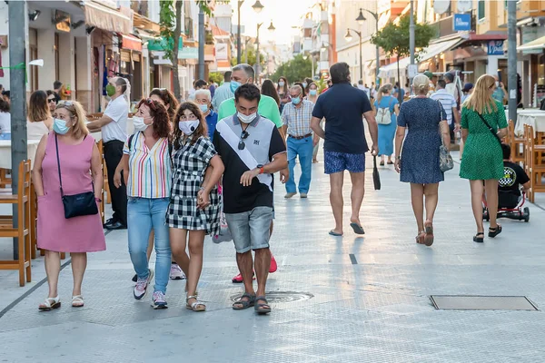 Punta Umbria, Huelva, İspanya - 10 Temmuz 2020: İnsanlar covid-19 nedeniyle koruyucu maske takarak sokakta yürüyorlar. İspanya 'da yeni normal