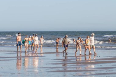 Punta Umbria, Huelva, İspanya - 2 Ağustos 2020: Koruyucu veya tıbbi maske takmış bir sürü insan sahilde yürüyor. Sosyal mesafeyle İspanya 'da yeni normal