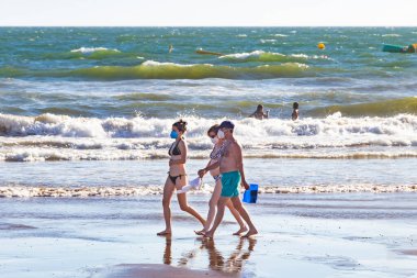 Punta Umbria, Huelva, İspanya - 2 Ağustos 2020: İnsanlar sahilde koruyucu veya tıbbi maske takarak yürüyor. Sosyal mesafeyle İspanya 'da yeni normal