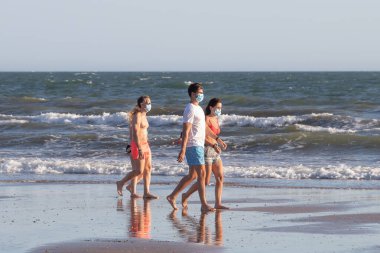 Punta Umbria, Huelva, İspanya - 2 Ağustos 2020: İnsanlar sahilde koruyucu veya tıbbi maske takarak yürüyor. Sosyal mesafeyle İspanya 'da yeni normal