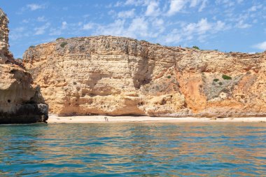Carvoeiro sahilinin manzarası. Lagoa bölgesinde yüksek uçurumlar, turkuaz sular ve pitoresk plajlardan oluşan bir kıyı şeridi vardır. Carvoeiro sahilleri korunaklı koylarda bulunur.