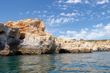 Lagoa bölgesinin kayalıklarından suya atlayan ve diğerleri de tüplü dalış yapan insanların manzarası. Yüksek uçurumlardan, turkuaz sulardan ve pitoresk sahillerden oluşan kıyı şeridi.