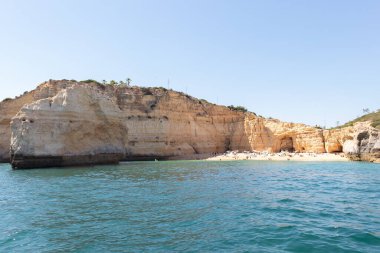 Carvoeiro sahilinin manzarası. Lagoa bölgesinde yüksek uçurumlar, turkuaz sular ve pitoresk plajlardan oluşan bir kıyı şeridi vardır. Carvoeiro sahilleri korunaklı koylarda bulunur.